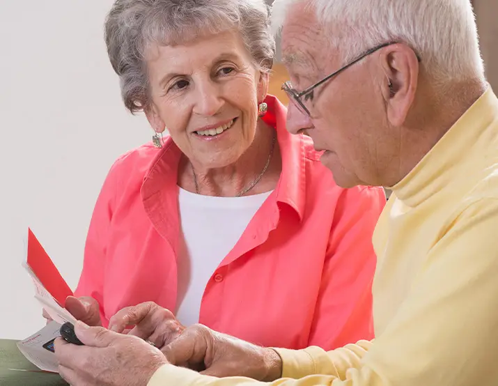 Elderly couple reading the instructions on how to use their new Personal Emergency Response System (PERS).