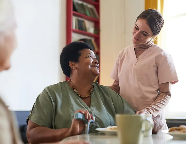 A female nurse comforting an elderly woman with a cane. Real-time response came after the fall detection feature of the PERS.